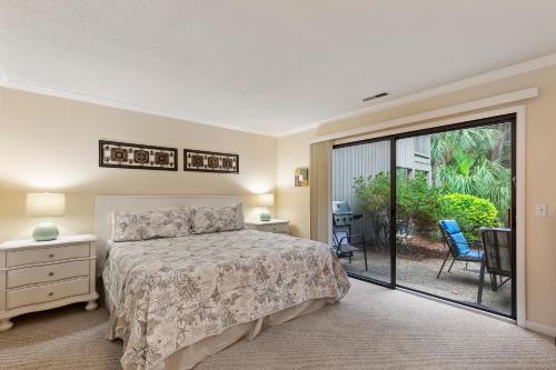 a bedroom with a bed and a sliding glass door at Tennismaster 505 in Hilton Head Island
