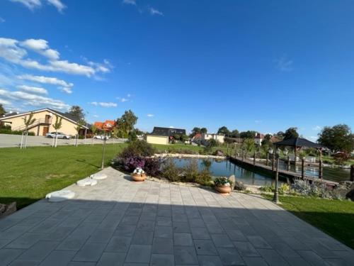 a stone walkway with a pond in a yard at Penzión a Reštaurácia Harmónia Ostratice in Malé Ostratice
