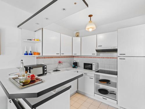 une cuisine avec des armoires blanches et un comptoir dans l'établissement Apartment Les Balcons d'Eze-2 by Interhome, à Èze