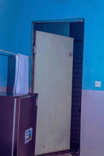 eine offene Tür zu einem Bad mit einem Kühlschrank in der Unterkunft Amadius in Lodwar