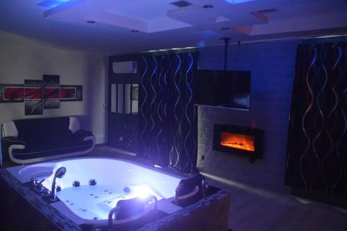 - un salon avec une baignoire et une cheminée dans l'établissement Love Room insolite Erotika, à Le Chesne