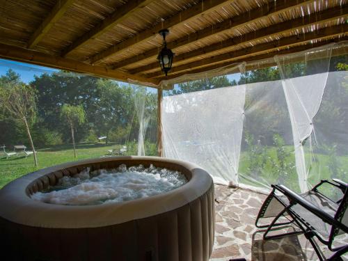 a large tub sitting on a patio with a window at Holiday Home Maya e Stella by Interhome in Bagni di Lucca