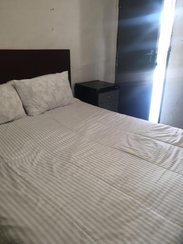 a bedroom with a bed with a white comforter at liam travel inn in Nelspruit