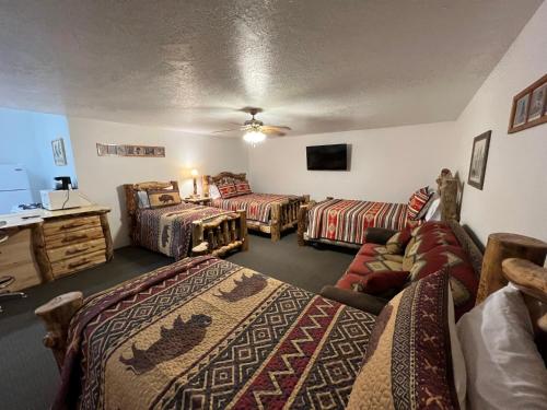 a room with three beds and a couch at THE SNUGGLE INN in Loa