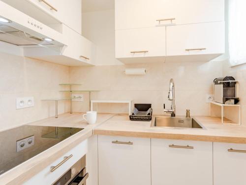 une cuisine avec des armoires blanches et un évier dans l'établissement Apartment Mirabeau by Interhome, à Deauville