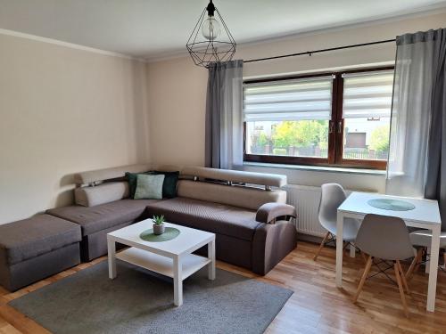 - un salon avec un canapé et une table dans l'établissement Pokoje Gościnne Perła, à Brenna