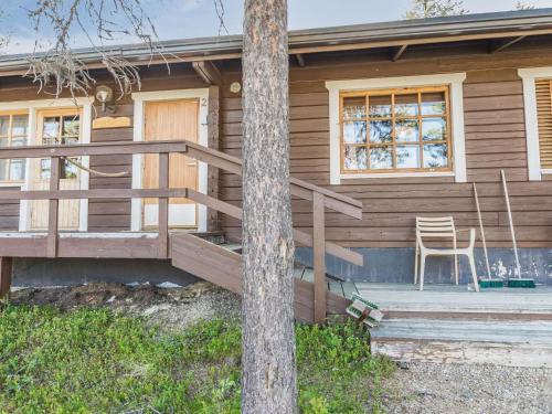 une maison en bois avec une chaise sur la terrasse couverte dans l'établissement Holiday Home Metsänpirtti 2 by Interhome, à Saariselka