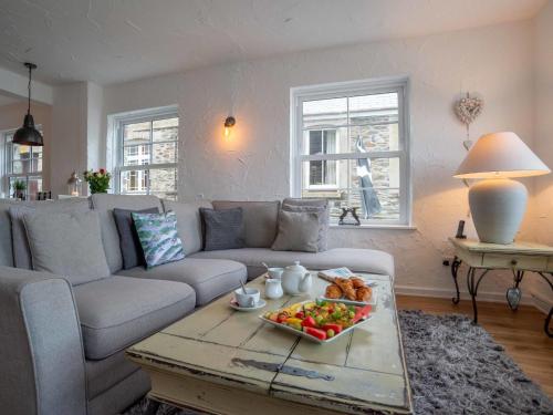 a living room with a couch and a tray of food on a table at Apartment Lighthouse View by Interhome in Mevagissey