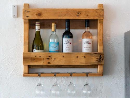 a wooden wine rack with wine bottles and glasses at Apartment Lighthouse View by Interhome in Mevagissey