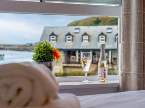 a bottle of champagne and a glass on a window sill at Apartment Lighthouse View by Interhome in Mevagissey