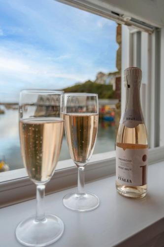 two glasses of champagne sitting next to a window at Apartment Lighthouse View by Interhome in Mevagissey