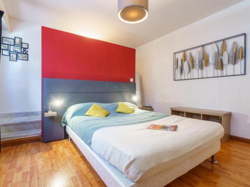 une chambre avec un grand lit avec un mur rouge dans l'établissement Apartment Résidence Impériale by Interhome, à Biarritz