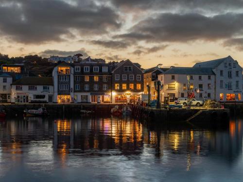 a view of a harbor with buildings and the water at Apartment Lighthouse View by Interhome in Mevagissey
