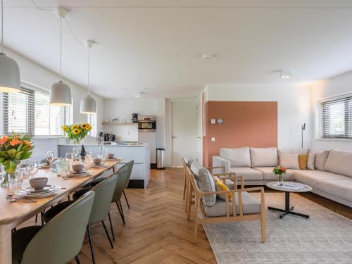 ein Esszimmer und ein Wohnzimmer mit einem langen Esstisch in der Unterkunft Holiday Home Duyndomein Noordwijk by Interhome in Noordwijk
