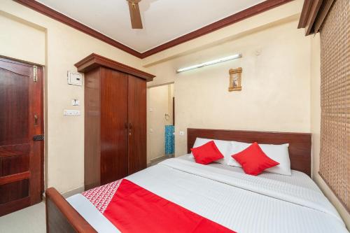 um quarto com uma cama com almofadas vermelhas em OYO Sr Pradeep Park em Chennai