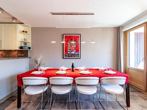 a dining room with a red table and white chairs at Apartment Le Shamrock - Le Lac-6 by Interhome in Tignes