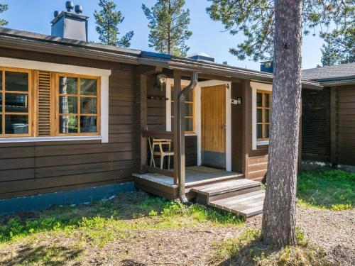 una pequeña casa con un porche y un árbol en Holiday Home Metsänpirtti 4 by Interhome, en Saariselkä