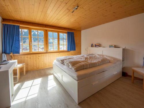 a bedroom with a bed in the corner of a room at Apartment Uf dr Fuhre by Interhome in Adelboden