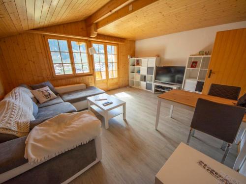 a living room with a couch and a table at Apartment Uf dr Fuhre by Interhome in Adelboden