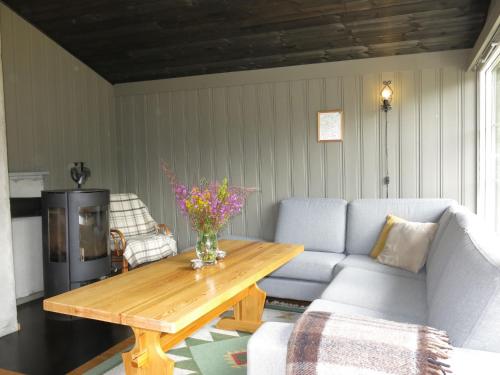 a living room with a couch and a wooden table at Holiday Home Bjørnnåslia - SOW161 by Interhome in Åseral