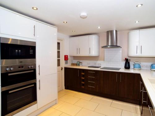 a kitchen with white cabinets and a stove top oven at Apartment Helland by Interhome in Pentewan