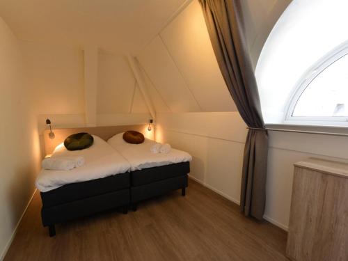 a small bed in a room with a window at Holiday Home Citta Romana by Interhome in Hellevoetsluis