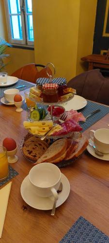 a wooden table with plates of food on it at Chambres d’hôtes La Joyeuse in Préveranges