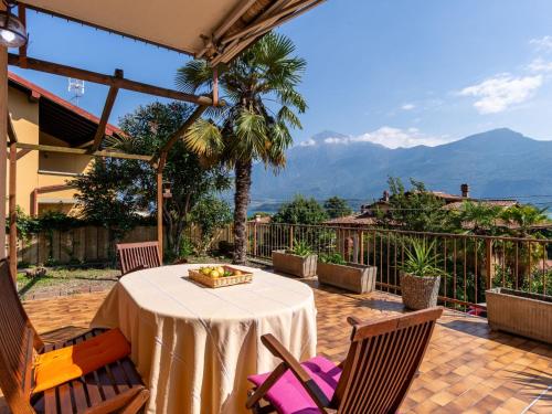 a table and chairs on a patio with mountains in the background at Apartment Dada by Interhome in Domaso
