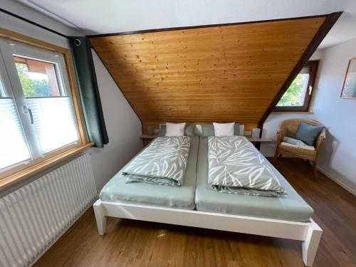 Bett in einem Zimmer mit Holzdecke in der Unterkunft Holiday Home Landhaus Klara by Interhome in Eisenbach