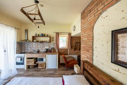 a living room with a brick wall and a kitchen at Dvůr Pohody in Varnsdorf