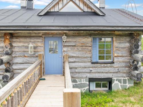 a wooden cabin with a blue door and a porch at Holiday Home Lymys by Interhome in Saariselka
