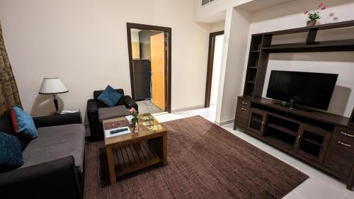 a living room with a couch and a flat screen tv at City Tower Hotel in Fujairah