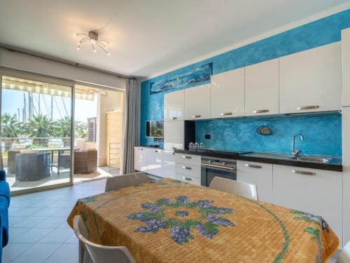 a kitchen with white cabinets and a table with chairs at Apartment Blue Moon by Interhome in Santo Stefano al Mare