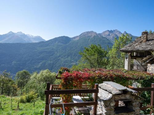 a house with flowers on it and mountains in the background at Apartment Baita del Celtico by Interhome in Advise