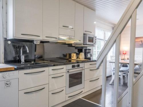 a kitchen with white cabinets and a stove top oven at Holiday Home Levin gaissa by Interhome in Levi