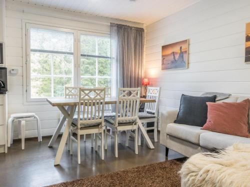 a living room with a table and chairs and a couch at Holiday Home Levin gaissa by Interhome in Levi