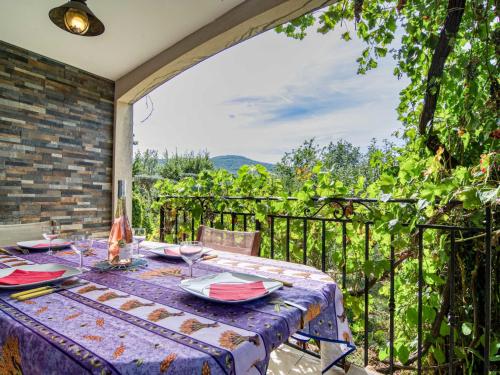 una mesa en un patio con vistas a las viñas en Apartment Mas des Grives by Interhome en Bauduen