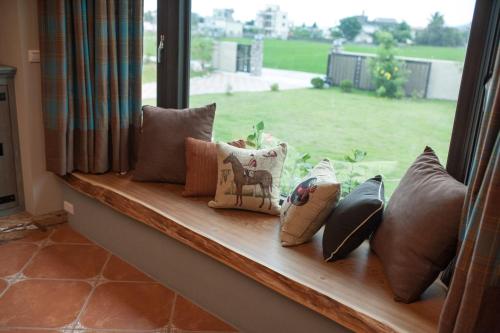 a window with pillows on a window sill with a view at 心享庭園民宿 Wishes B&B in Jian