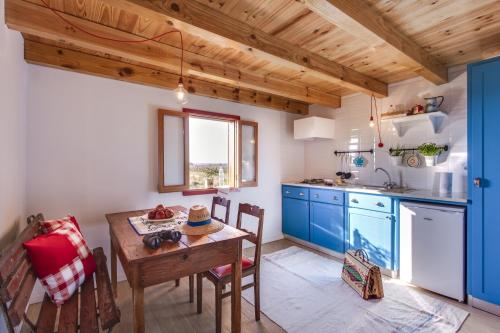 a kitchen with blue cabinets and a wooden table at Be and See in Nature in Ovar