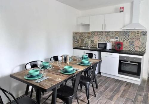 uma cozinha com uma mesa de madeira com pratos verdes em *Studio 1* Avenue Baudin - DABNB em Limoges
