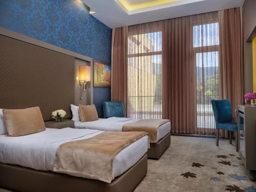 a hotel room with two beds and a window at Qafqaz Tufandag Mountain Resort Hotel in Gabala