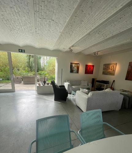a living room with couches and chairs in a room at Polderlicht in Blankenberge
