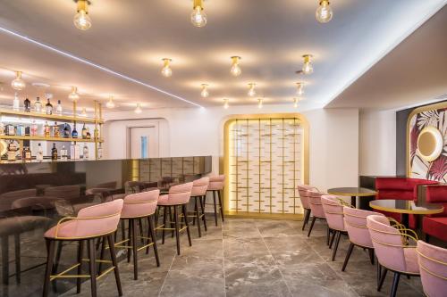 a restaurant with pink chairs and tables and a bar at Barceló Fortina Malta in Sliema
