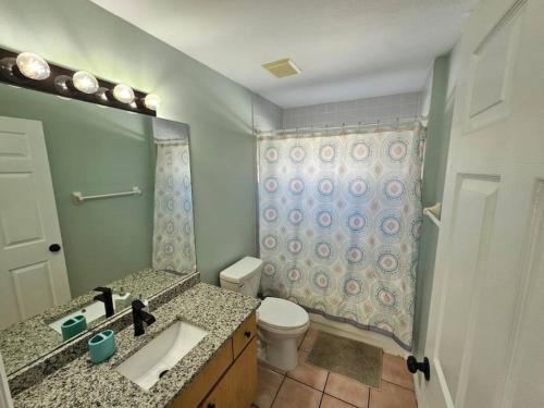 y baño con lavabo, aseo y ducha. en Simple house 5 beds 4 baths near Beach, en Clearwater
