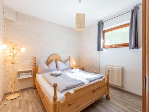 una camera con letto in legno e finestra di Cozy apartment in Feichten with terrace 