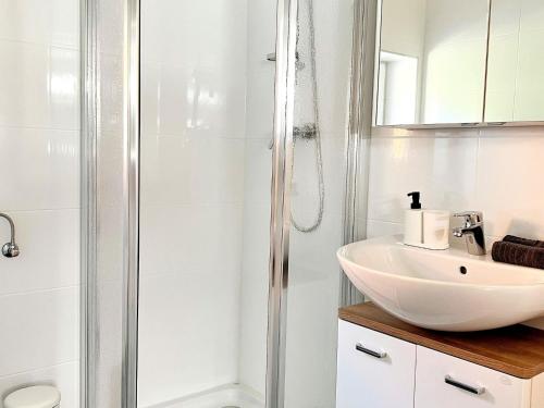 a white bathroom with a sink and a shower at Holiday Home in Spielberg near Red Bull Ring in Spielberg