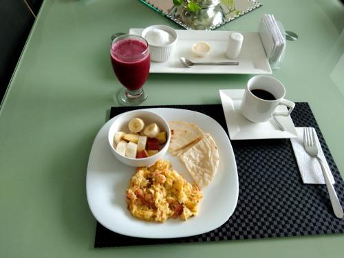 a table with a plate of breakfast food and a drink at Casa palma Cartagena de Indias, Colombia in Cartagena de Indias