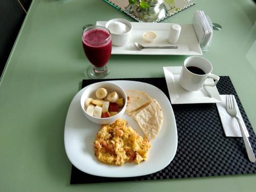 a table with a plate of breakfast food and a drink at CASA PALMA CARTAGENA in Cartagena de Indias