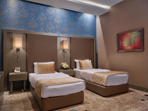 a hotel room with two beds and two lamps at Qafqaz Tufandag Mountain Resort Hotel in Gabala