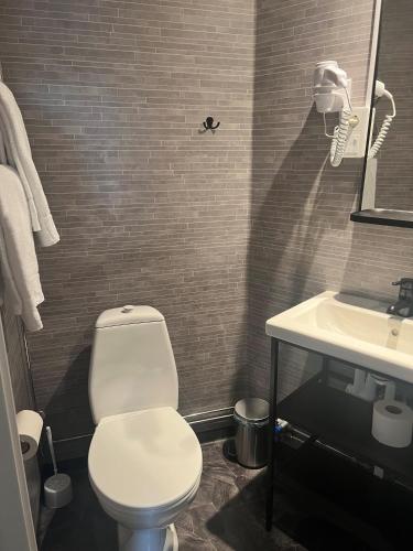 a bathroom with a white toilet and a sink at Hotel E-10 by First in Kiruna